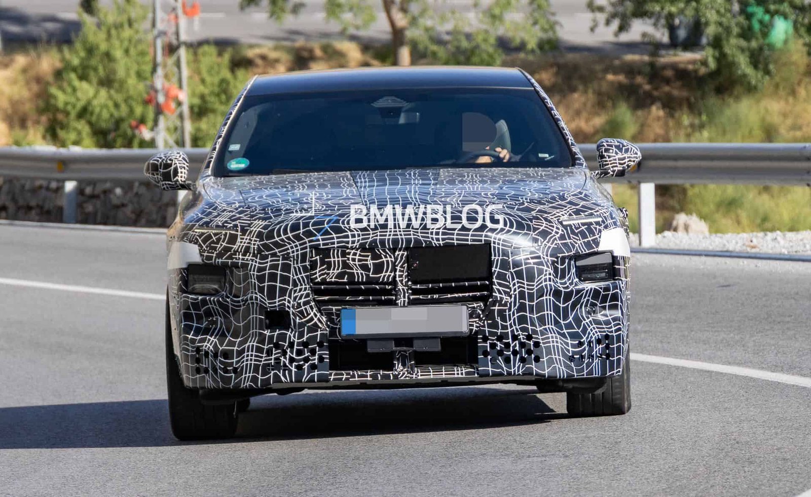 2027 BMW 7 Series facelift prototype showing split headlights and camouflaged front bumper during testing