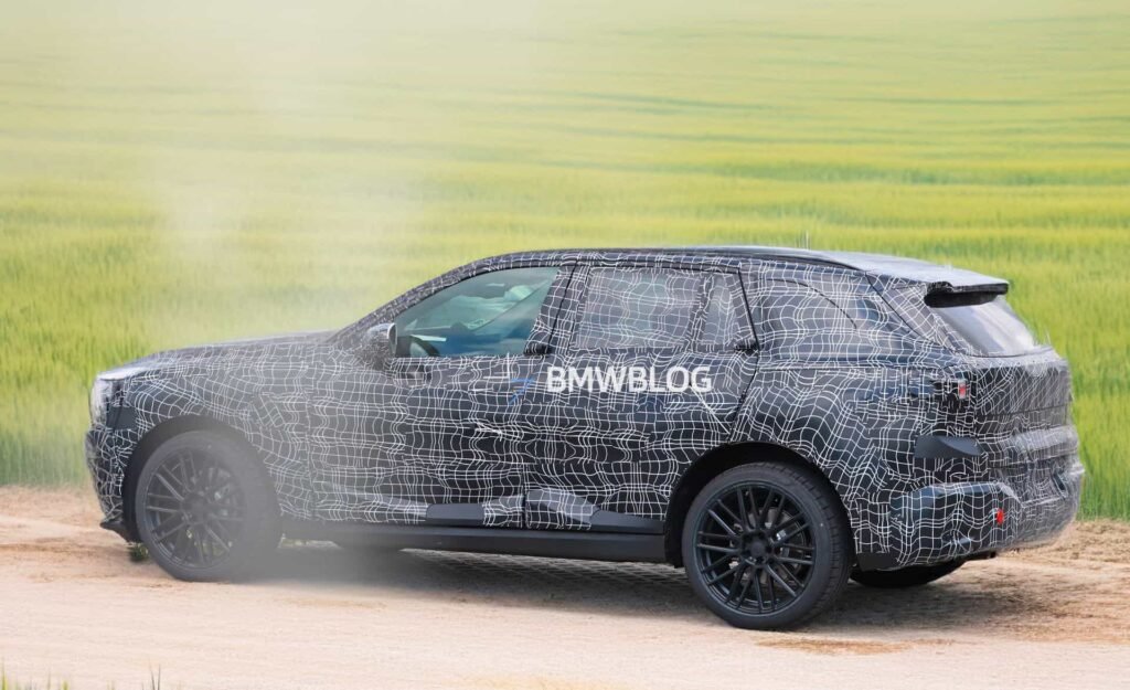 Camouflaged 2027 BMW X5 G65 prototype testing on Autobahn with Vision Neue Klasse–style hidden door handles