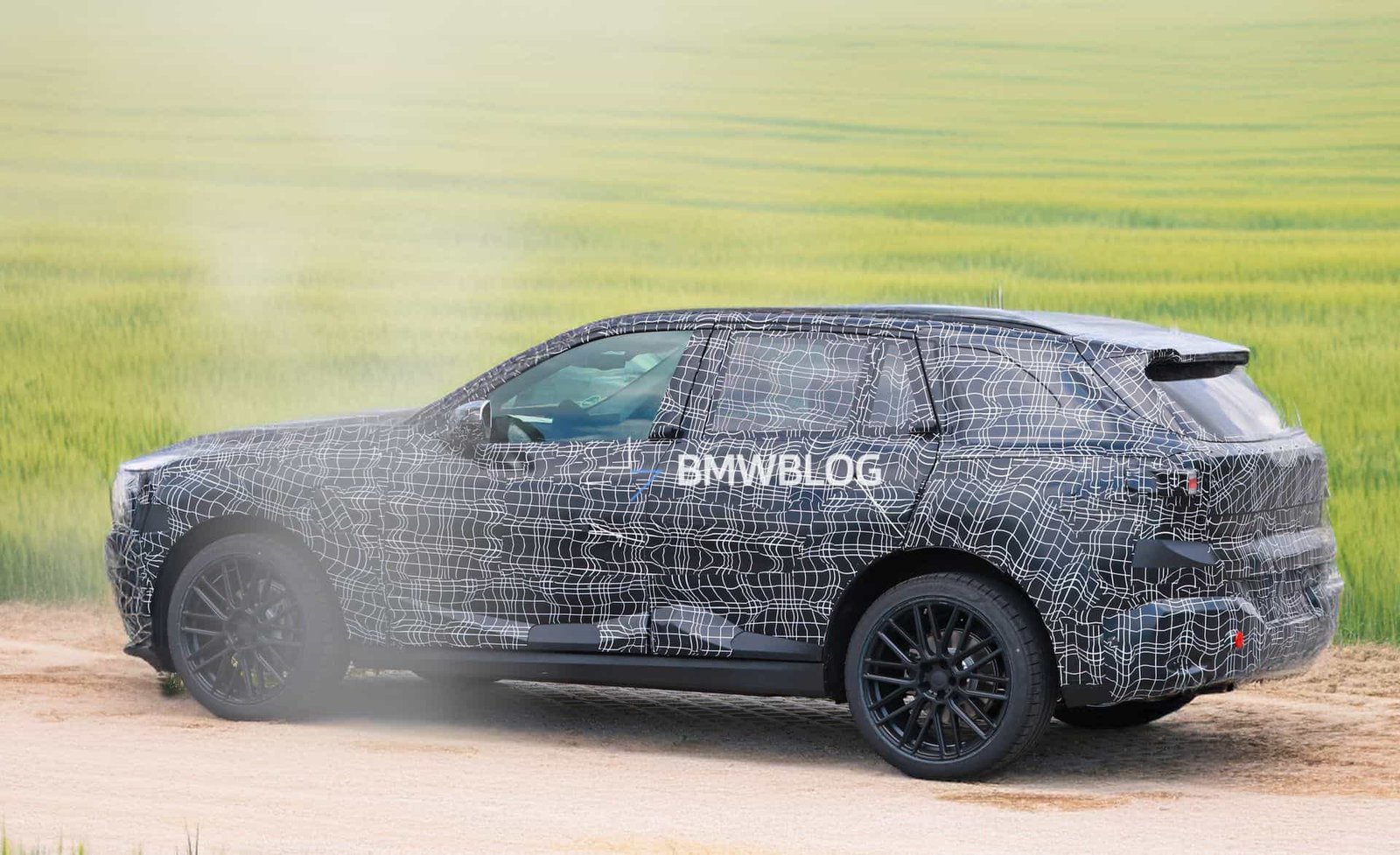 Camouflaged 2027 BMW X5 G65 prototype testing on Autobahn with Vision Neue Klasse–style hidden door handles
