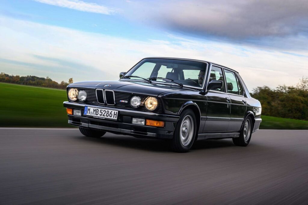 E28 BMW M5 in black driving on the street