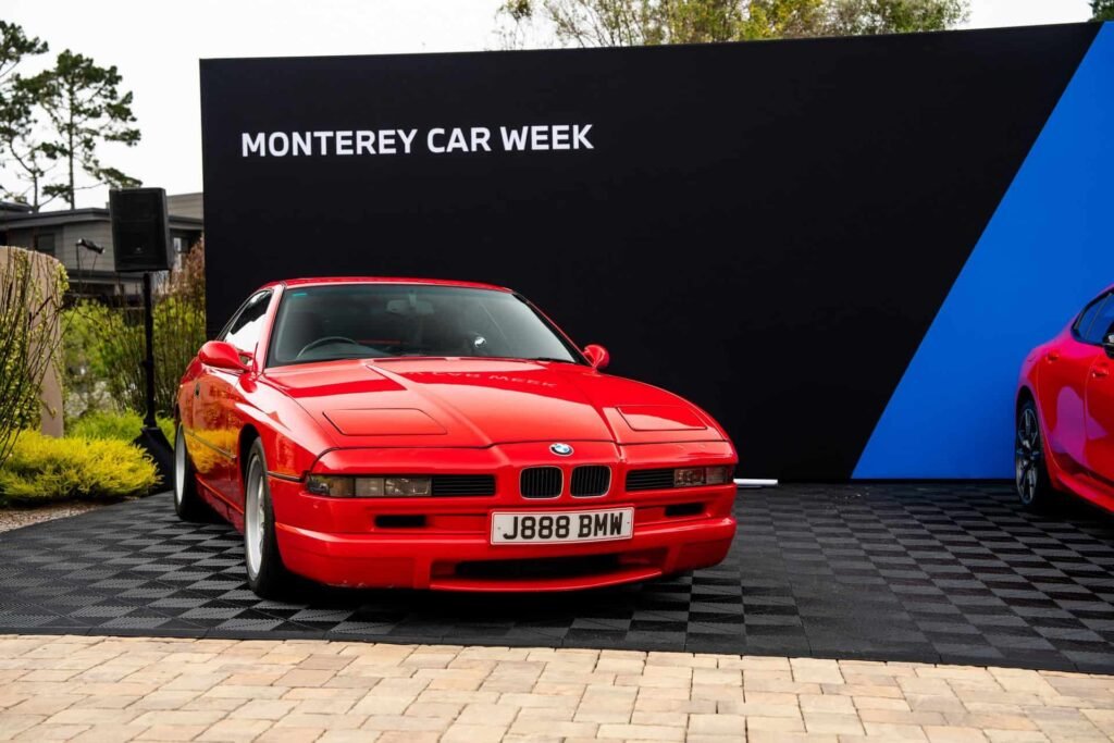 Japan-spec right-hand drive BMW 850CSi in Bright Red next to 2026 M850i Heritage Edition at Pebble Beach