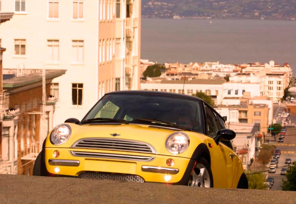First-generation R50 MINI Cooper driving through San Francisco streets during the early 2000s relaunch